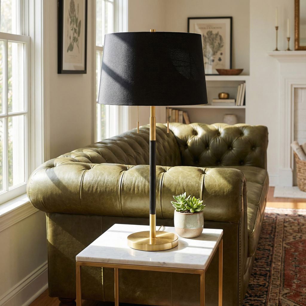 Couture Archer table lamp beside a green sofa in a sunlit living room