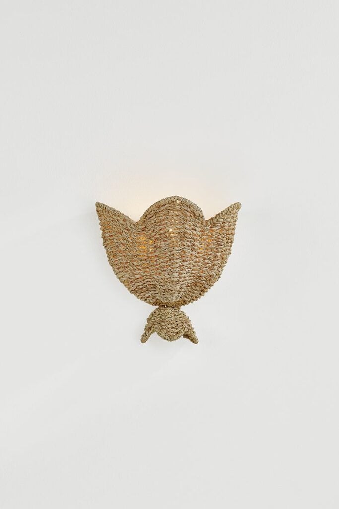 Mitzi Solie wall sconce illuminated against a white wall